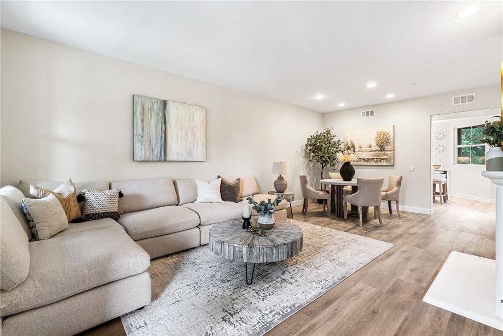 A living room with a sectional sofa and a dining table beyond